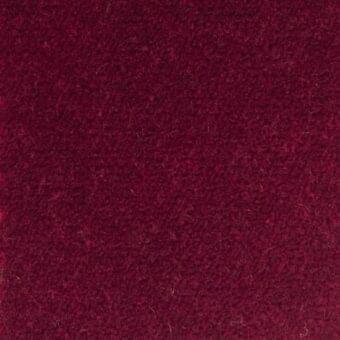Red woven textile with a dense, slightly irregular pile and muted, earthy tone exhibiting a subtly mottled surface texture.